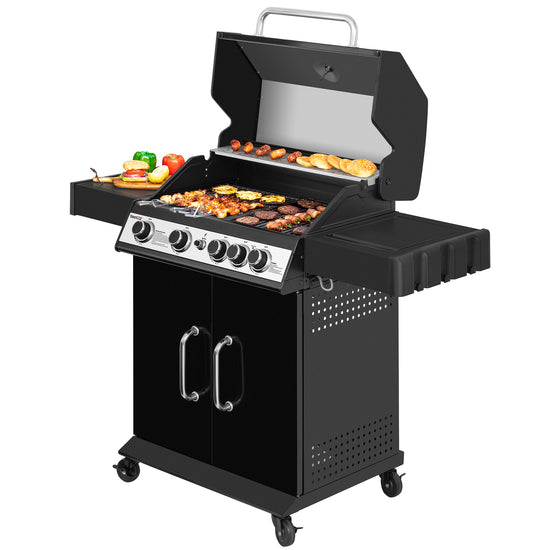 A black gas grill with a lid, side tables, and four wheels, shown with food cooking on the grates and a side plate with vegetables. The grill has a silver control panel with six knobs.