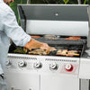 Person grilling on a large outdoor Royal Gourmet  grill with various meats and vegetables.