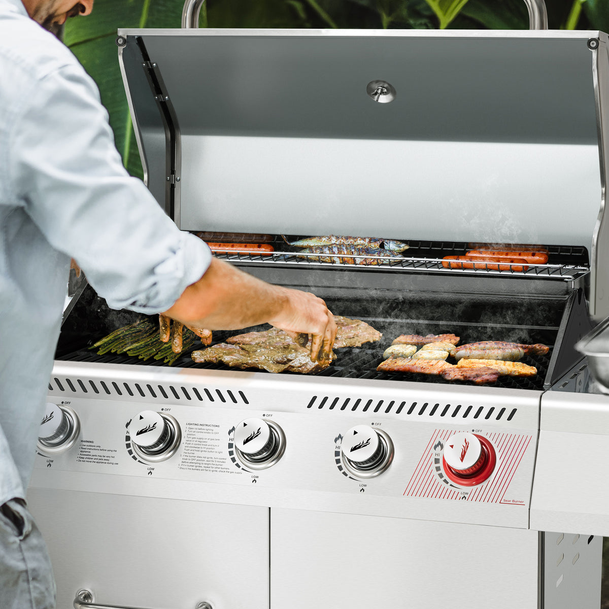 Person grilling on a large outdoor Royal Gourmet  grill with various meats and vegetables.