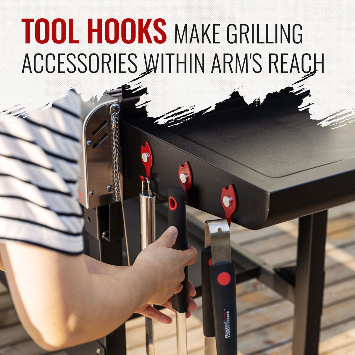 A person's hand hangs a tool from a black grill's side-mounted hook, with other tools stored on the hook. Large text at the top reads 'TOOL HOOKS MAKE GRILLING ACCESSORIES WITHIN ARM'S REACH'.