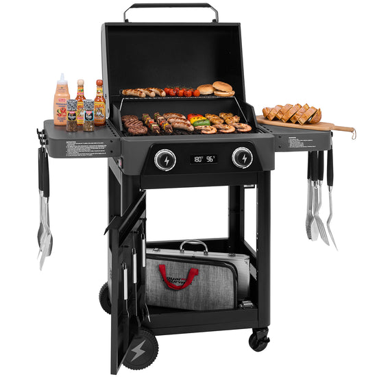 A black 3-in-1 Royal Gourmet gas grill cart with an open lid, loaded with food on the grates and side tables, shown on a white background. The cart includes side tables holding bottles and utensils, a lower storage shelf with a bag, and control knobs on the front.