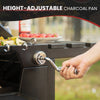 Hand adjusting a height-adjustable charcoal pan on a Royal Gourmet grill with vegetables and tomatoes in the background.