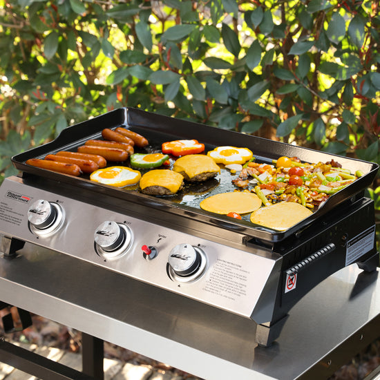 Royal Gourmet Portable grill with food cooking on a natural outdoor background