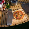 Sliced pizza on a wooden cutting board with a Royal Gourmet spatula, surrounded by drinks and condiments on a wooden table.