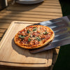 Small pizza on a wooden board with a Royal Gourmet  metal spatula