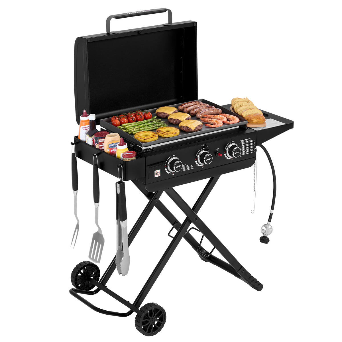 A black portable folding Royal Gourmet gas grill with wheels, shown open with food cooking on the griddle and side tray. The grill has two control knobs, hanging utensil holders with tongs and spatulas, and a clean white studio background.