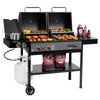 A black Royal Gourmet double-grill propane barbecue system with two cooking compartments, side shelves holding food, condiments, a pot, and a white propane tank on a clean white background.