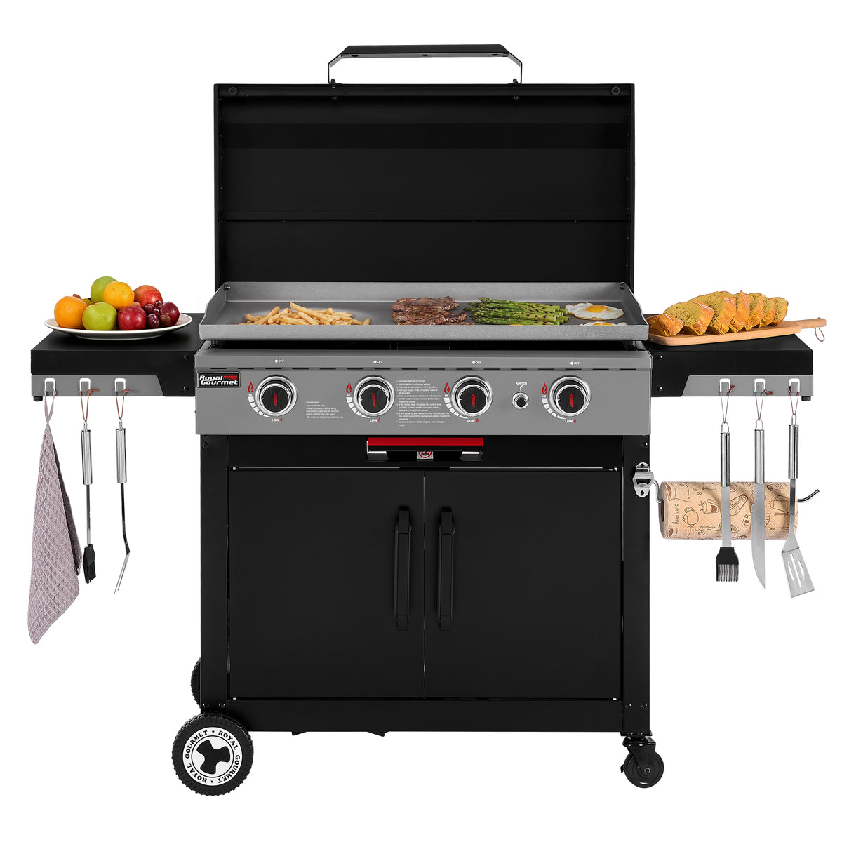A black Royal Gourmet gas grill with an open lid, shown on a white background with food and grilling accessories arranged around it. The grill has a flat top griddle with fries, steak, asparagus, and eggs, and side tables holding fruit, bread, towels, and utensils.